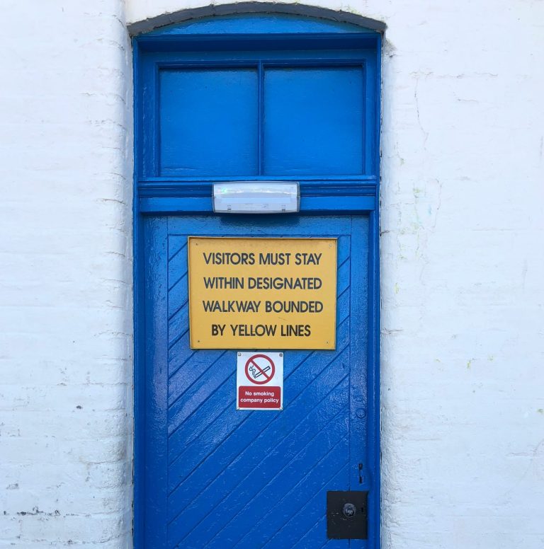 Sign on a door reads “Visitors must stay within designated boundary,” emphasizing the importance of respecting personal or physical limits.
